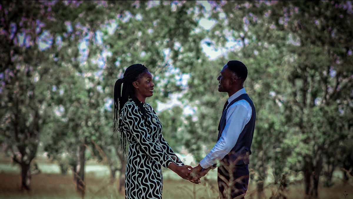 A man and a woman holding hands in a field